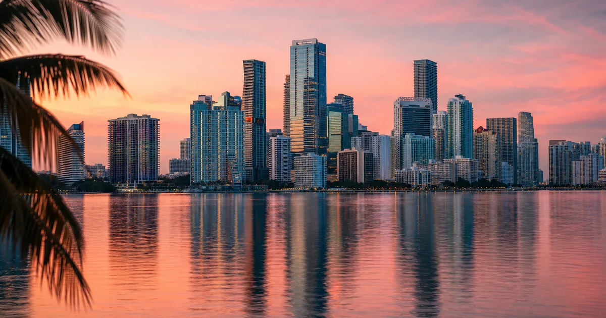 Glass office towers in Miami's Brickell financial district reflecting afternoon light with palm trees in the foreground